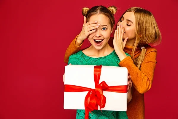 model-covering-eyes-her-friend-giving-her-big-gift-box-haring-secret